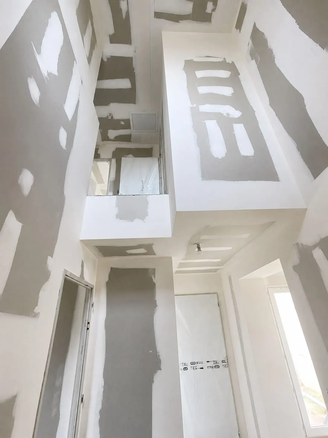 Cage d'escalier en plaques de plâtre avec retombées de plafond et bandes à joints — chantier en Lot-et-Garonne