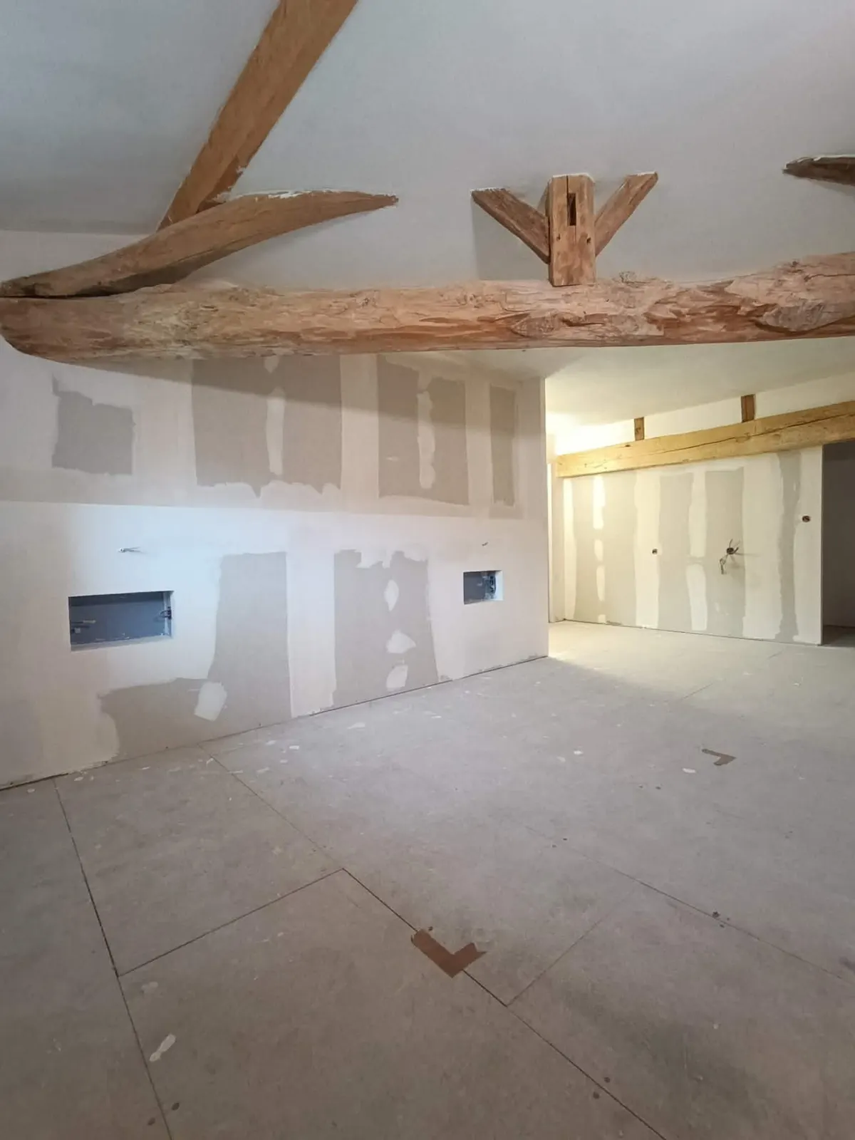 Chambre parentale créée en placo avec niches et tablette intégrée sous poutres anciennes — rénovation secteur Marmande (47)